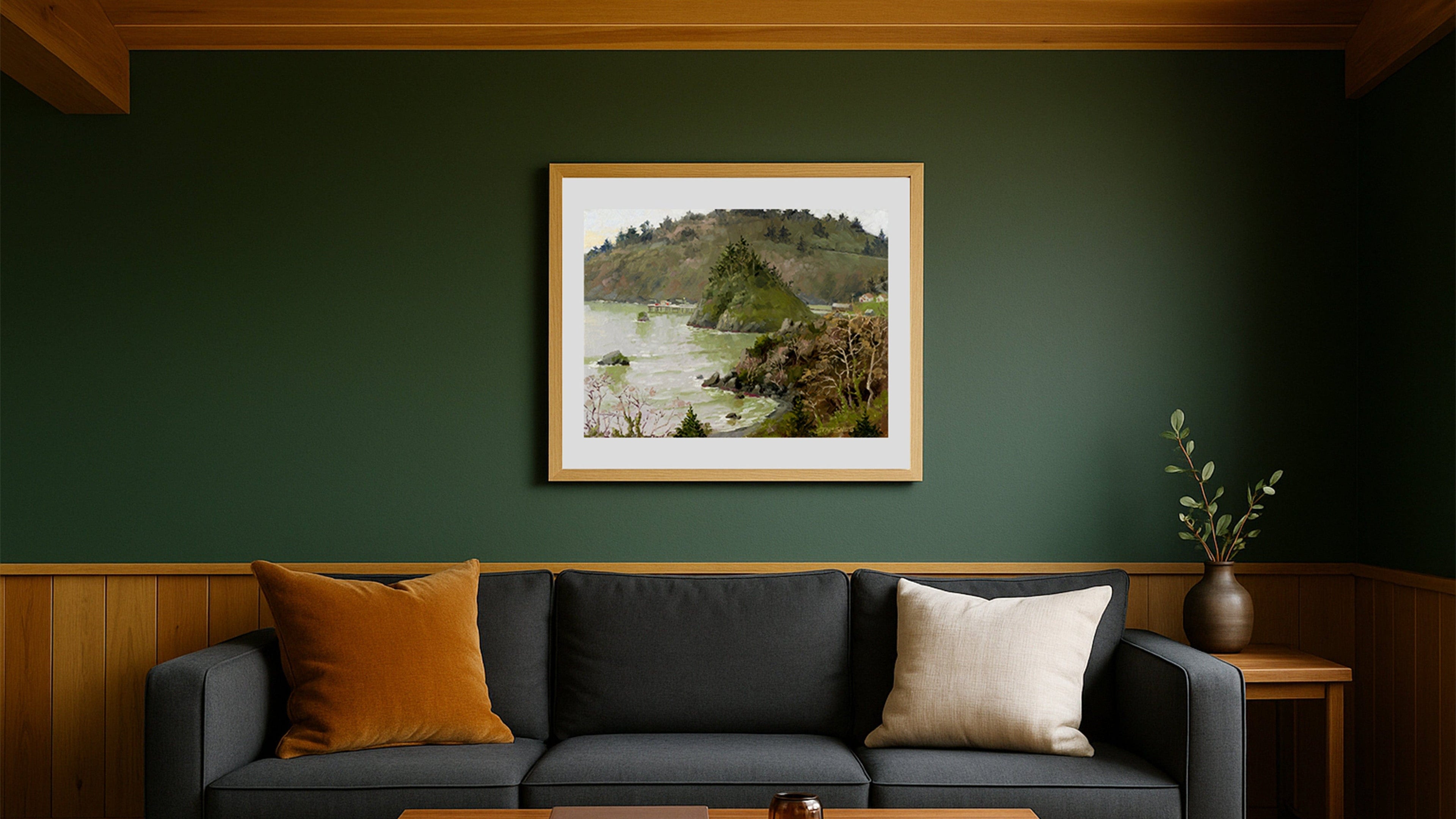 Living room with a gray sofa, wooden coffee table, and framed picture on a green wall.
