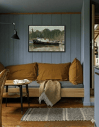Cozy living room with a brown sofa, wooden coffee table, and framed artwork on the wall.
