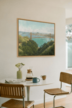 Dining room with a round table, chairs, and a painting of a landscape of the Golden Gaate Bridge painted by Leo Stafsnes.